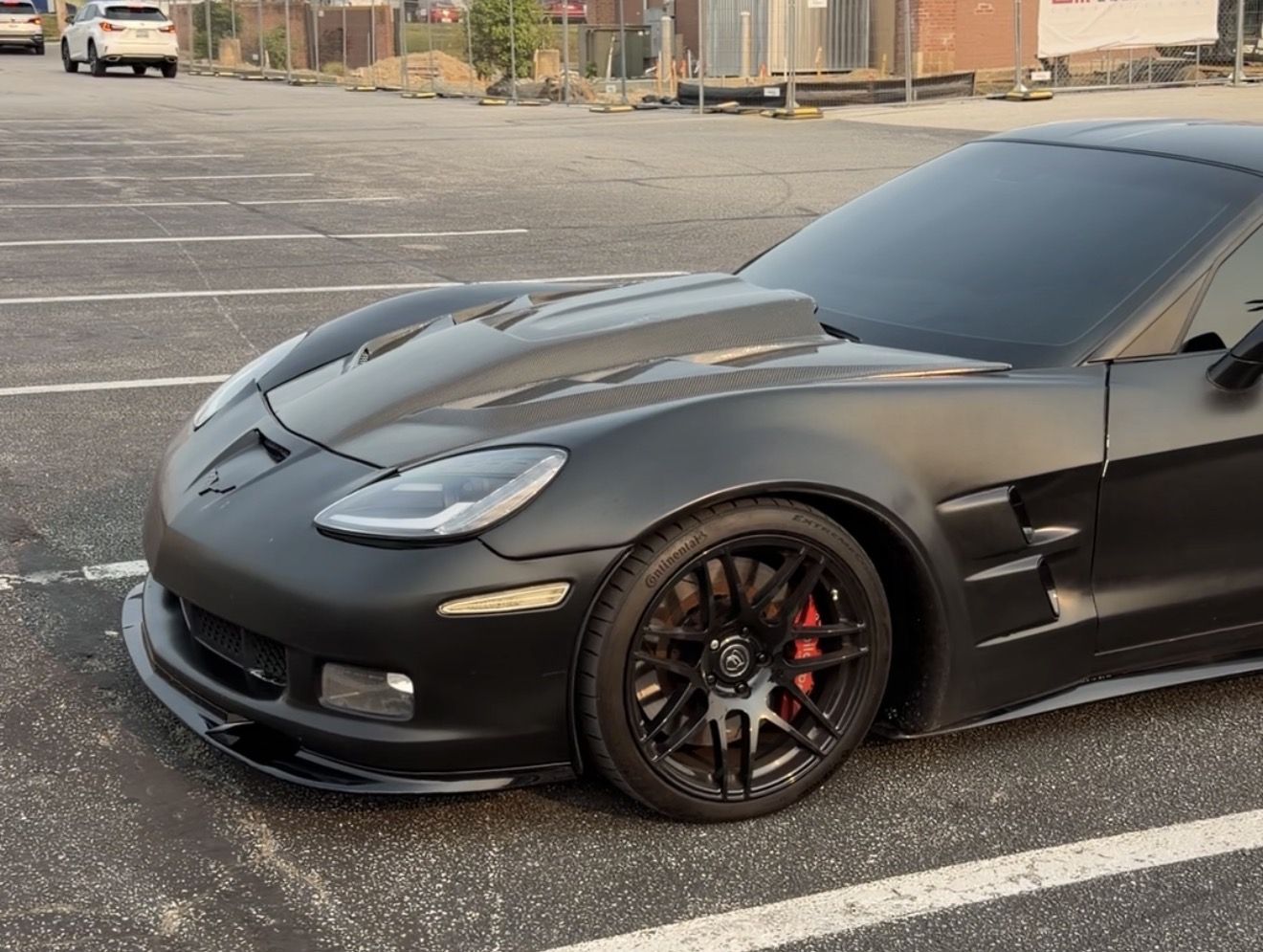 Widebody C6 Corvette, front three-quarter, matte black with red calipers